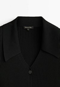 Cardigan noir en maille côtelée avec un large col et un seul bouton noir, étiquette de la marque « Massimo Dutti » visible à l'intérieur de l'encolure.