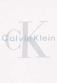Λευκό ύφασμα με κεντημένο ανοιχτό μπλε κείμενο "Calvin Klein", διαθέτοντας ένα μεγάλο "CK" με εφέ σκιάς, με ομαλή υφή και καθαρό σχεδιασμό.