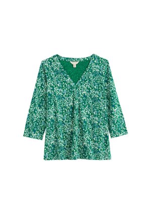 Bluza verde cu mânecă lungă și decolteu în V, cu model floral alb și albastru, detaliu adunat sub decolteu, așezată pe o suprafață albă.