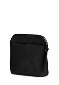 Černé pouzdro z texturované umělé kůže se zlatým kováním, zapínáním na zip a jemným logem značky. Kompaktní tvar s bočním střapcem.