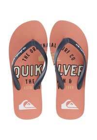 Chanclas Quiksilver con una plantilla texturizada en color coral y tiras negras que presentan un logotipo. El texto impreso en la plantilla incluye el nombre de la marca y el año.