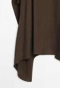 Brown fabric draped with an asymmetrical hem against a white background.
