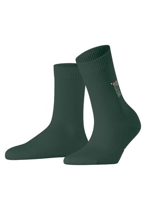 Groene katoenen sokken met een geribbelde bovenkant, voorzien van een gladde textuur en een klein "HO HO HO"-ontwerp aan de zijkant. Middellange lengte tot de kuit.