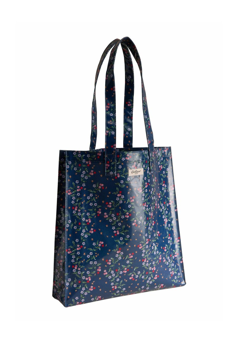 Mornarska cvetna torba iz svetlečega materiala, okrašena z večbarvnimi cvetovi in zvezdami, z dvema dolgima ročajema in kvadratno obliko.