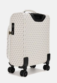 Valise blanche à motifs au design épuré, dotée d'une surface texturée, de roues noires et d'un verrou à combinaison sur le côté.