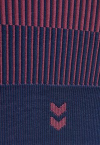 Nahaufnahme eines gerippten Stoffs mit vertikalen marineblauen und burgunderroten Streifen sowie zwei burgunderroten Chevron-Mustern auf marineblauem Hintergrund.