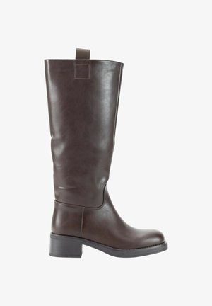 Bota de cuero marrón oscuro hasta la rodilla con un tacón bajo y una pestaña de agarre en la parte superior sobre un fondo blanco.