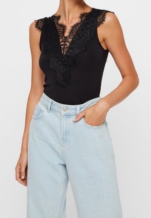 Body nero con rifiniture in pizzo, caratterizzato da una profonda scollatura a V e senza maniche, abbinato a jeans in denim blu chiaro a vita alta.
