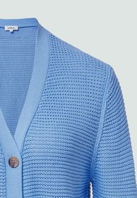 Hellblau gestrickte Strickjacke mit V-Ausschnitt, gerippten Bündchen und einem Holzknopf-Detail. Marmoriertes Muster im gesamten Design.