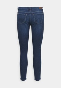 Mörkblå skinny jeans med en slät denimtextur, som har två bakfickor och en diskret logotypetikett på midjan.
