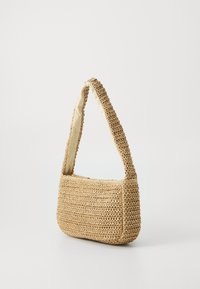 Sac à main en paille tissée de couleur beige clair, de forme rectangulaire, avec une bandoulière épaisse et une doublure en tissu lisse. Dispose d'une fermeture éclair en haut.