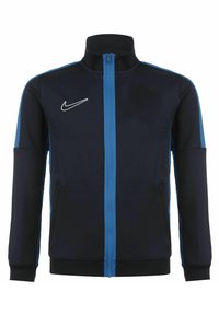 Chaqueta con cremallera de Nike en azul marino y azul claro, con cuello alto y el logo de Nike en blanco en el pecho izquierdo.