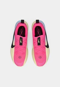 Ροζ ύφασμα στο πάνω μέρος με μαύρο λογότυπο Nike, κίτρινη σόλα, μπλε λεπτομέρειες στη φτέρνα και υφασμένα στοιχεία στα πλαϊνά. Διπλές θηλιές στο πίσω μέρος για εύκολη φόρεση.