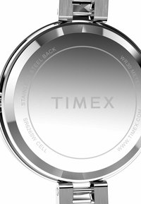 Le fond de la montre en acier inoxydable présente une surface polie avec des détails gravés, y compris "WR 30 METERS" et des informations sur la batterie.