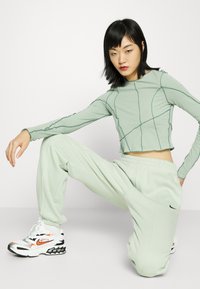 Nike Sportswear W NSW ESSNTL PANT FLC TREND - Calças de fato de treino - seafoam/black