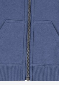 Modra zip-up kapuca iz mehkega blaga, ki ima dva sprednja žepa in rebraste manšete na robu, ter trden zadrgo.