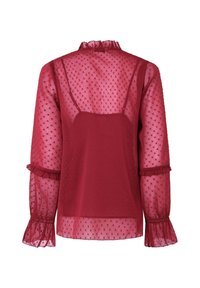 Blusa trasparente bordeaux con texture a pois, colletto arricciato e maniche a campana. Design stratificato con fodera interna aderente.