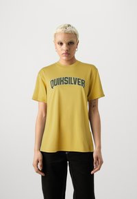 Yellow cotton t-shirt with short sleeves and round neck. Features a large "QUIKSILVER" logo in green across the chest.