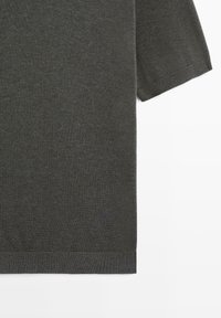 Pull tricoté gris foncé à manches courtes avec poignets et ourlet côtelés, posé à plat sur un fond blanc.