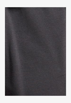 Primo piano di tessuto lavorato a maglia di colore grigio scuro con una fine trama a costine e una sottile piega verticale sul lato sinistro.