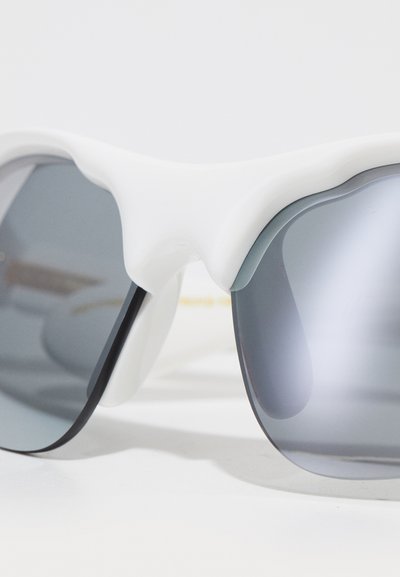 Occhiali sportivi da sole con montatura in plastica bianca, lenti grigie a sfumatura e design curvo. Presentano sottili stanghette nere.