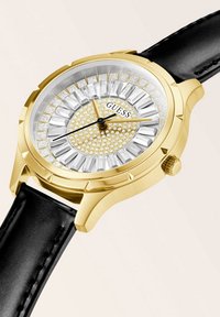 Goldfarbene Uhr mit rundem Ziffernblatt, Kristallakzenten, schwarzem Lederarmband, ausgestattet mit einem strukturierten Ziffernblatt, das eine Mischung aus goldenen und klaren Kristallen zeigt.