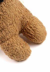 Jucărie de pluș maro deschis, moale, cu un exterior texturat și zbârcit. Lăbuțele rotunjite au cusături bine definite și o suprafață pufoasă și tactilă.