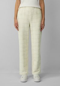 Lichtgele, gestructureerde broek met een rechte pijpdesign. Elastische tailleband, gemaakt van een geweven materiaal, gecombineerd met witte schoenen.