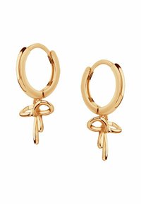 Złote kolczyki w kształcie obręczy o gładkim wykończeniu z delikatnym akcentem w postaci kokardki zwisającej z każdej obręczy. Projekt jest okrągły i wypolerowany.