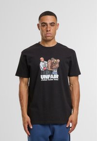 Schwarzes Baumwoll-T-Shirt mit einem grafischen Druck, der zwei Boxer und den Text "UNFAIR" in fetter weißer Schrift zeigt. Kurze Ärmel und runder Halsausschnitt.