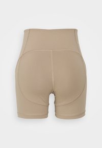 Shorts beige in mesh alta, realizzati in tessuto elastico con cuciture piatte e pannelli laterali arrotondati. Texture morbida, senza marchi visibili.