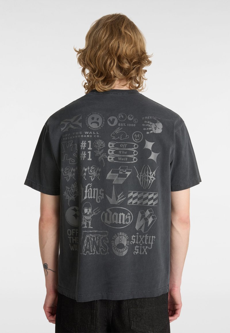 Grå t-shirt med korta ärmar som har olika tryckta logotyper och grafik i ljusare grå toner på baksidan.