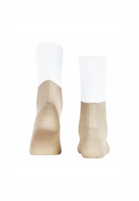 Kniestrümpfe mit einem weißen gerippten oberen Teil, der zu einem beige glatten Körper übergeht; verfügt über eine verstärkte Ferse und Zehen.