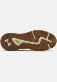 Gumowa podeszwa z falistym wzorem bieżnika, w kolorze białym i beżowym, z małym zielonym akcentem. Widoczne logo Under Armour.