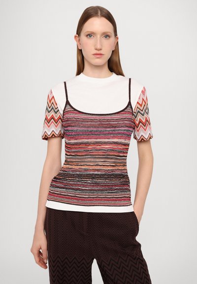 Top multicolor cu dungi, cu mâneci scurte, având un design tricotat texturat, contur negru și un aspect stratificat, asortat cu pantaloni închis și cu model.
