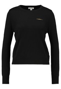 Svarttröja med långa ärmar, ribbad nederkant och rund halsringning. Har guldbroderad text som säger "Jag tror." Slät textur.