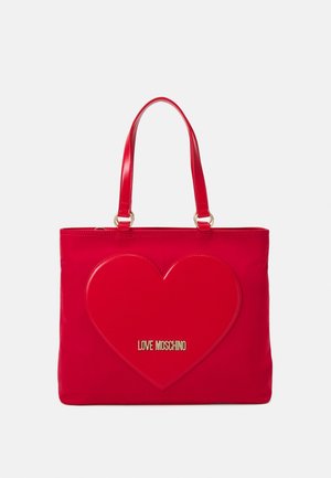 Sac tote rouge avec une finition brillante, présentant un grand motif en forme de cœur à l'avant. Logo doré "LOVE MOSCHINO" affiché en évidence.
