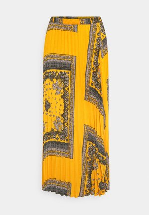 Jupe midi plissée jaune avec imprimé bandana cachemire et floral noir et blanc, style portefeuille asymétrique.