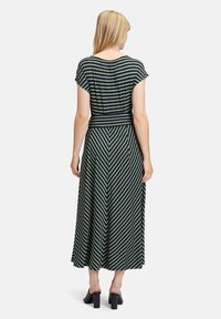 Sukienka maxi w ciemnozielone i granatowe paski, z krótkimi rękawami, wcięciem w talii i zwiewnym spódnicą w kształcie litery A. Gładki materiał z lekkim połyskiem.