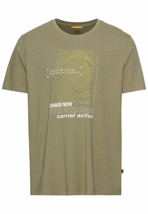 Olijfgroene katoenen T-shirt met korte mouwen. Bevat gele en witte grafische tekst, waaronder "ONBEPERKTE AVONTURIER" en contourlijnen.