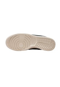 Nike-Schuhsohle mit einem strukturierten beigen Gummi, das kreisförmige und lineare Muster aufweist. Der schwarze obere Rand ist entlang des Designs sichtbar.
