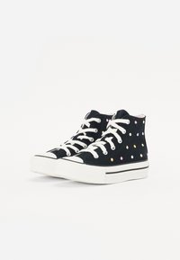 Zwarte hoge sneakers met witte veters, voorzien van kleurrijke stippen, een textiel bovenwerk en een witte rubberen zool met zwarte strepen.