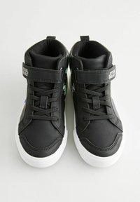 Schwarze High-Top-Sneaker mit glattem Kunstledersockel, weißen Gummisohlen, verstellbarem Klettverschluss und grünen grafischen Akzenten.