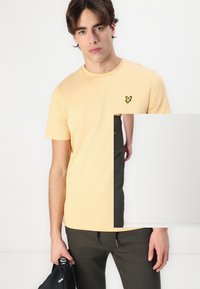 Yellow cotton t-shirt with a crew neck and short sleeves, featuring a small black and yellow logo on the left chest.