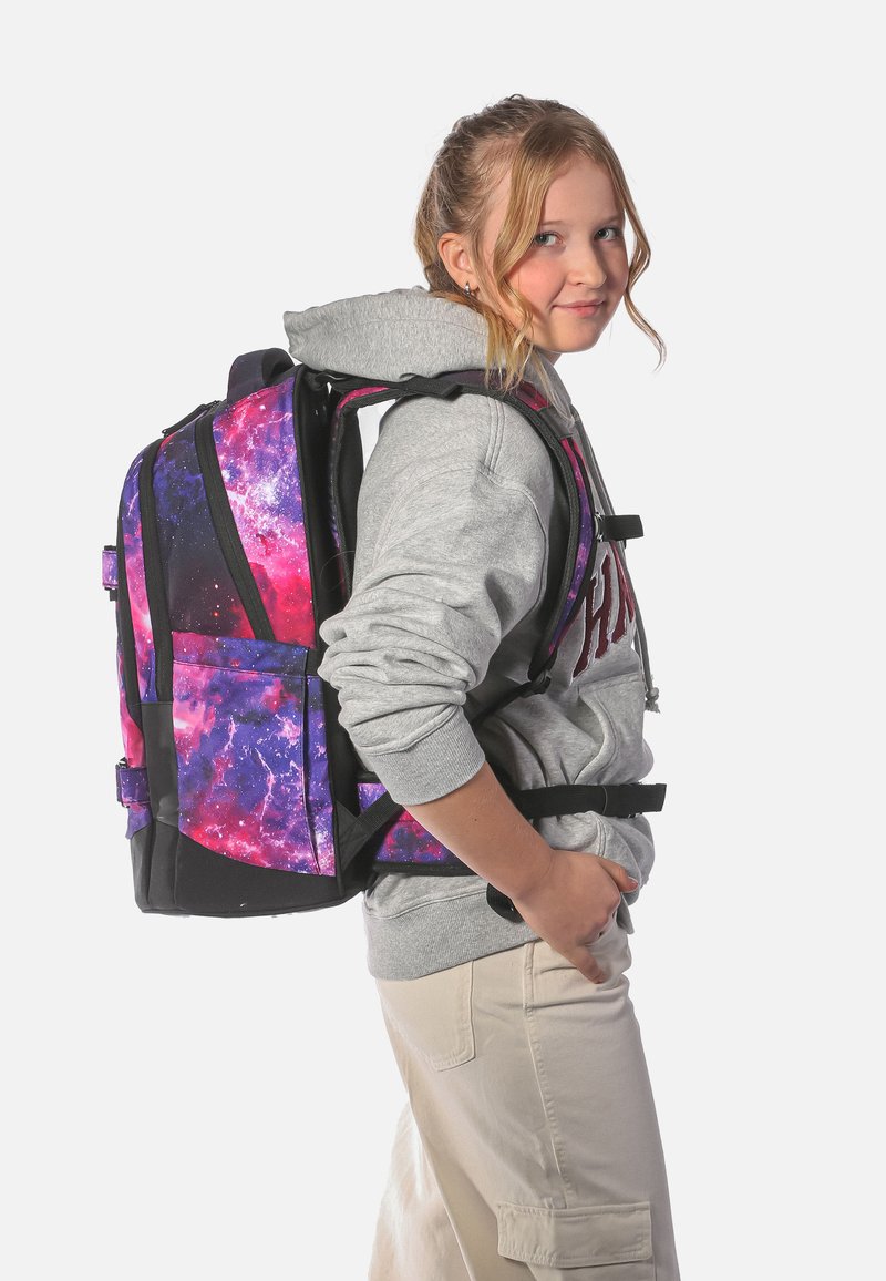Batoh s galaxiovým vzorem má fialové a růžové vzory s černými akcenty. Nastavitelné popruhy a více přihrádek pro úložný prostor.