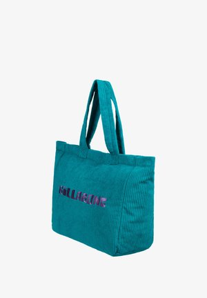 Tyrkysová kordurová taška s dvoma ušami, s vyšitým logom "Billabong" v ružovej a fialovej farbe. Textúrovaný povrch, obdĺžnikový tvar.