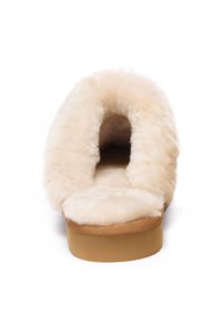 Beige faux fur slip-on shoe with a wide opening and soft interior. Flat platform sole with a light brown bottom. No visible hardware or patterns.