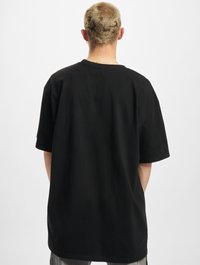 Sort bomulds t-shirt med afslappet pasform, korte ærmer og rund hals. Glat tekstur uden synlige mønstre eller detaljer.
