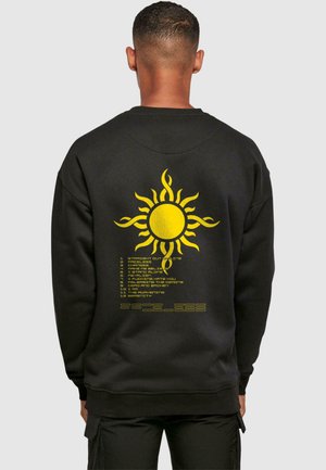 Black sweatshirt with a yellow sun graphic on the back, featuring text beneath it. Made of soft material with ribbed cuffs and hem.