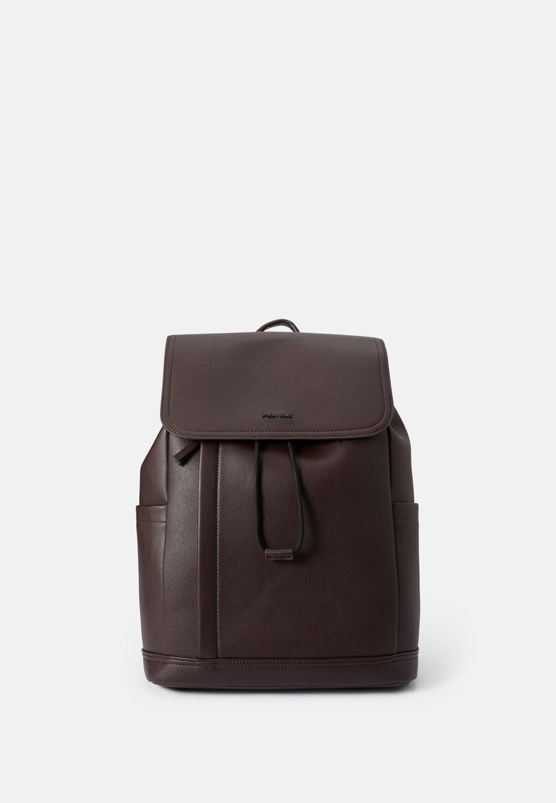 Mochila de cuero marrón oscuro con cierre de solapa, correas ajustables y bolsillos laterales. Textura suave con sutiles detalles de costura.